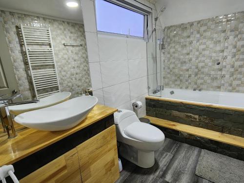 y baño con lavabo, aseo y bañera. en Nui 2 apartamento, en Punta Arenas
