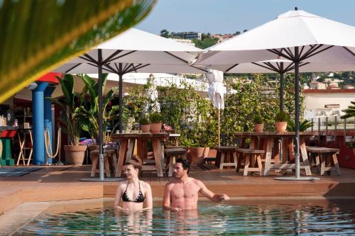 2 hommes dans la piscine d'un hôtel dans l'établissement AC Hotel by Marriott Nice, à Nice
