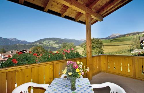 a table with a vase of flowers on a balcony at Pension Volgger in Rodengo