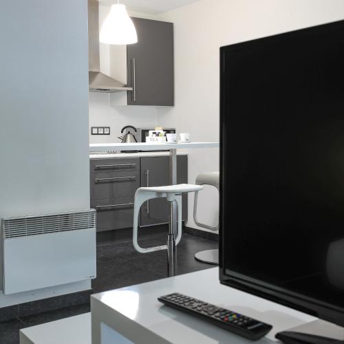 a computer monitor sitting on a desk in a kitchen at Hotel Bô Rivage in Neufchâteau