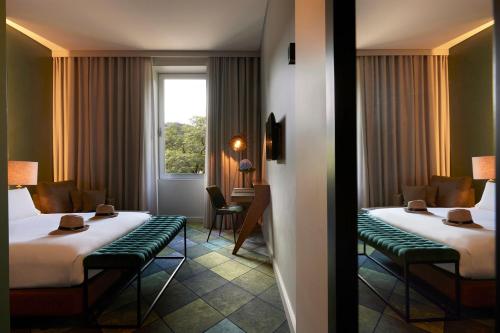a hotel room with two beds and a window at Octant Furnas in Furnas