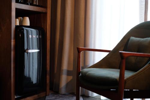 a living room with a chair and a tv at Octant Furnas in Furnas