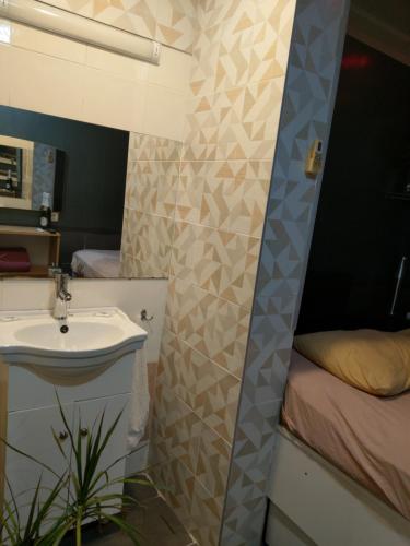 baño con lavabo y cama en Paralax Hotel, en Varna