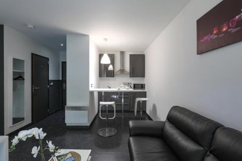 ein Wohnzimmer mit einem Sofa und einer Küche in der Unterkunft Hotel Bô Rivage -- Eden-Ardenne in Neufchâteau