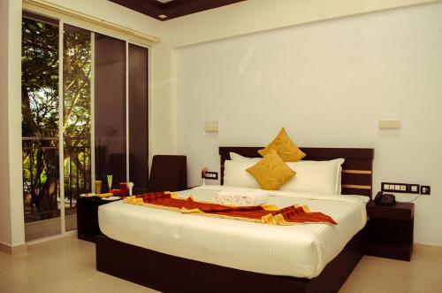 a bedroom with a large bed and a large window at Leela Backwater Inn in Trivandrum