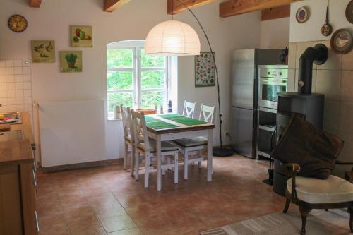 a kitchen with a table and chairs and a refrigerator at Altes Waschhaus in Putbus