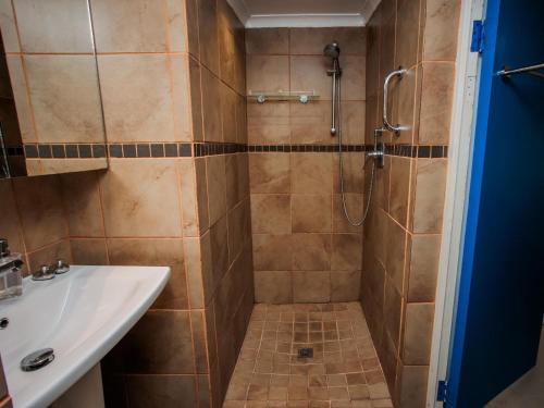 un baño con ducha y lavabo en Gifted Garden Cottage, en Swellendam