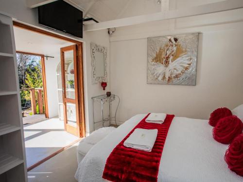 Un dormitorio con una cama con una manta roja encima. en Gifted Garden Cottage, en Swellendam