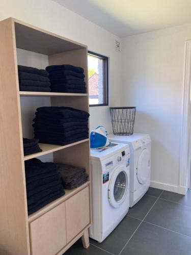 a laundry room with a washer and a washing machine at Vakantiehuis Zand7 in Lommel