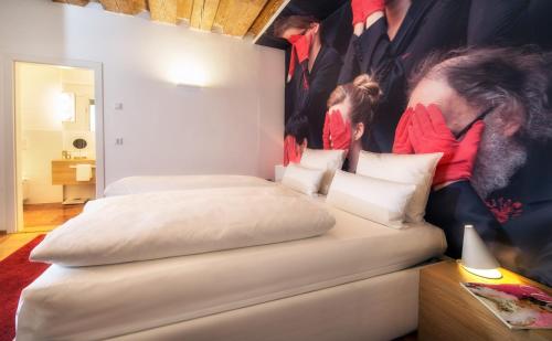 two beds in a room with a large poster on the wall at Small Luxury Hotel Goldgasse in Salzburg