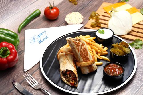 a plate of food with a sandwich and french fries at Ayass Hotel in Amman
