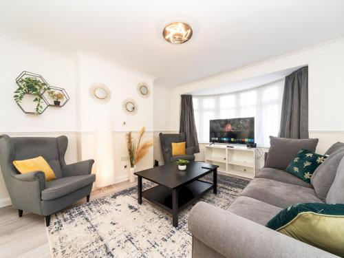 a living room with a couch and chairs and a tv at Spacious 4 Bed House Free Parking Near Station - Pass the Keys in Bexleyheath