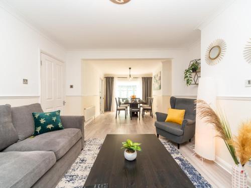 a living room with a couch and a table at Spacious 4 Bed House Free Parking Near Station - Pass the Keys in Bexleyheath