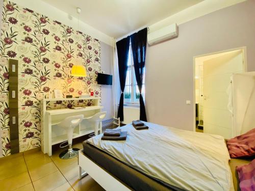 1 dormitorio con cama, lavabo y escritorio en Purple Room - Stylish and lively central studio en Budapest