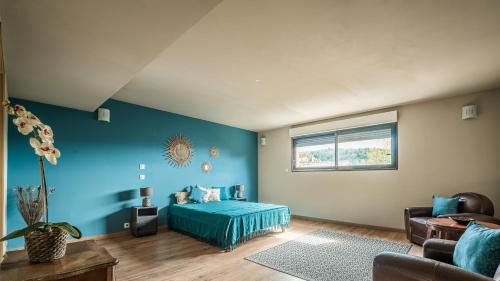 um quarto com paredes azuis e uma cama num quarto em Au Paradis des 2 Petites Abeilles em Félines-Minervois