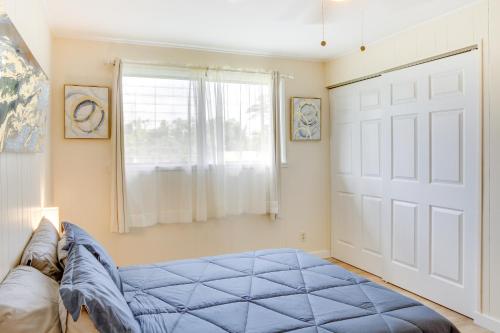 a bedroom with a blue bed in front of a window at Walk to Downtown Hilo Condo with Pool Access! in Hilo
