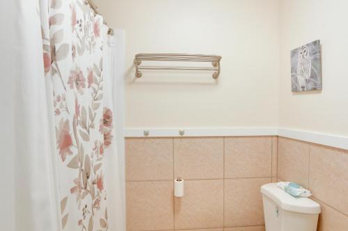 a bathroom with a toilet and a shower curtain at Quaint Hilo Vacation Rental with Community Pool! in Hilo