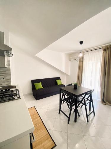 a living room with a table and a couch at Defa Apartment in Giardini Naxos