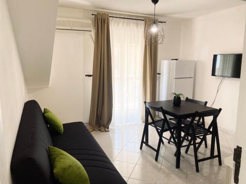 a living room with a black couch and a table at Defa Apartment in Giardini Naxos