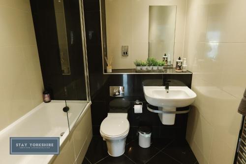 a bathroom with a sink and a toilet and a bath tub at Stay Yorkshire City Centre Apartments in Sheffield