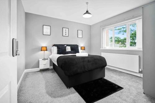um quarto com uma cama e uma janela em Showcase Estates em Birmingham