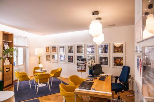 ein Büro mit gelben Stühlen und einem Schreibtisch mit einem Computer in der Unterkunft Small Luxury Hotel Goldgasse in Salzburg