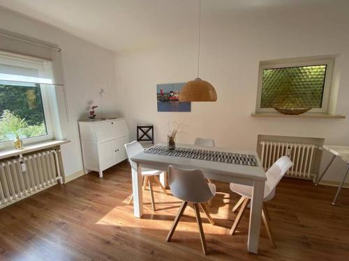 a dining room with a white table and chairs at FEDDERSEN LIVING Große Ferienwohnung - Garten - Terrasse - Smart TV - Netflix in Brunsbüttel
