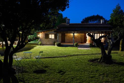 una casa con cenador en un patio en CASA DO COMBRO, en Ponteareas