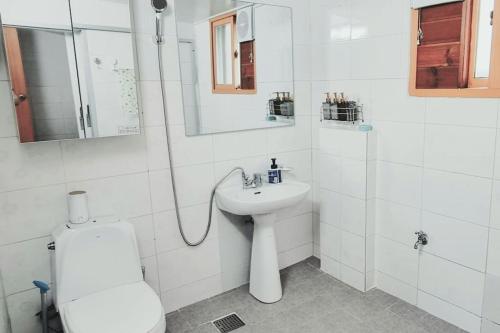 ein weißes Bad mit einem Waschbecken und einem WC in der Unterkunft Tongyeong Hue Stay in Tongyeong