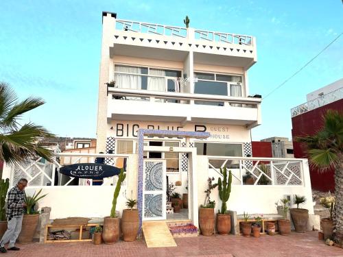 a man standing in front of a white building at BIG BLUE guest house in Imsouane
