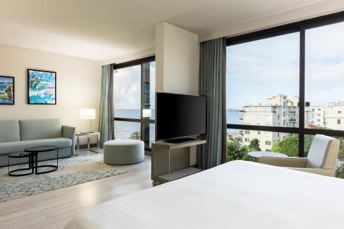 pokój hotelowy z łóżkiem i dużym oknem w obiekcie AC Hotel by Marriott Nice w Nicei