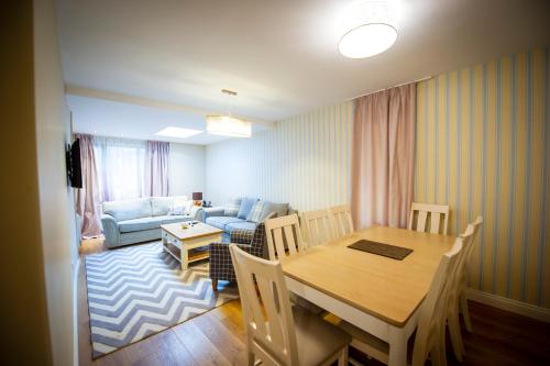a living room with a dining room table and a couch at Predela 2 Aparthotel in Bansko