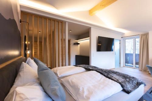 a bedroom with two white beds and a television at Landhaus Riepler in Wagrain