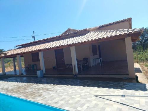 una casa con terraza junto a una piscina en Chácara do Cardoso, en Três Marias