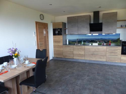 une cuisine avec une longue table et une grande cuisine dans l'établissement Ferienwohnung Steger, à Mattsee