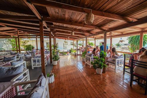 a restaurant with people sitting in chairs in a room at Vila Era Beach in Sarandë
