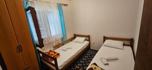 two beds in a small room with a window at Vila Lena Banja Vrujci in Berkovac