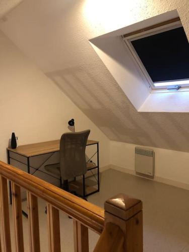 Cette chambre comprend une chaise, un bureau et une télévision. dans l'établissement Plaisancier by Póm, à Lorient