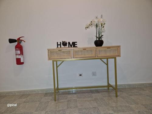 a table with a vase of flowers on top of it at Casa Almeida - Castelo Branco in Castelo Branco