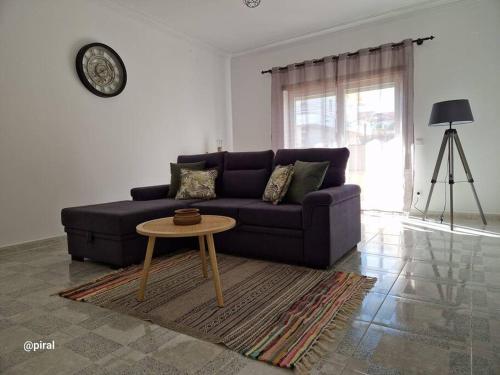 a living room with a purple couch and a table at Casa Almeida - Castelo Branco in Castelo Branco