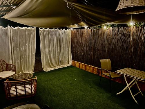 a room with a tent with green carpet and chairs at Domaine Plan des Devens in Roussillon