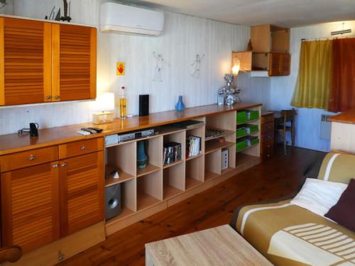 uma sala de estar com uma cozinha com armários de madeira em UN CHALET EN BOIS A LA PLAGE em Gruissan
