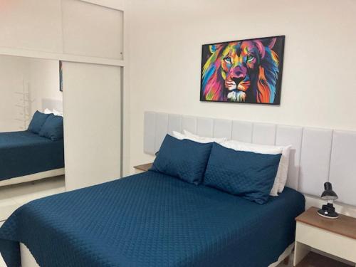 une chambre avec un lit bleu et une peinture d'un lion dans l'établissement Barrabela 130, à Rio de Janeiro