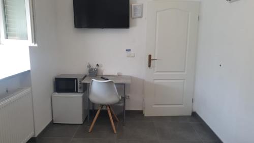 a white kitchen with a white chair and a counter at Pension Bad Soden / Apartment and Rooms in Bad Soden am Taunus