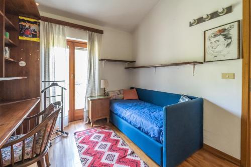 a blue couch in a room with a staircase at Visogliano Roomy Apt w/ Terrace near the Station in Sistiana