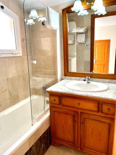 a bathroom with a sink and a tub and a shower at Aparthotel Bahia Pinosol in Jávea