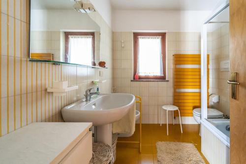 La salle de bains est pourvue d'un lavabo et de toilettes. dans l'établissement Visogliano Roomy Apt w/ Terrace near the Station, à Sistiana