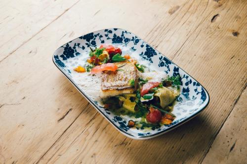 a blue and white plate of food on a wooden table at Small Luxury Hotel Goldgasse in Salzburg