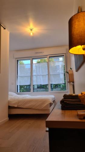 um quarto com uma cama e uma grande janela em BIENVENUE88 em Chessy
