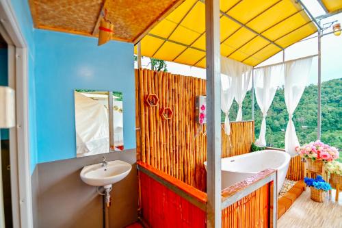 ein Badezimmer mit einer Badewanne und einem Waschbecken in der Unterkunft ภูสกาย โฮมสเตย์ in Mon Jam